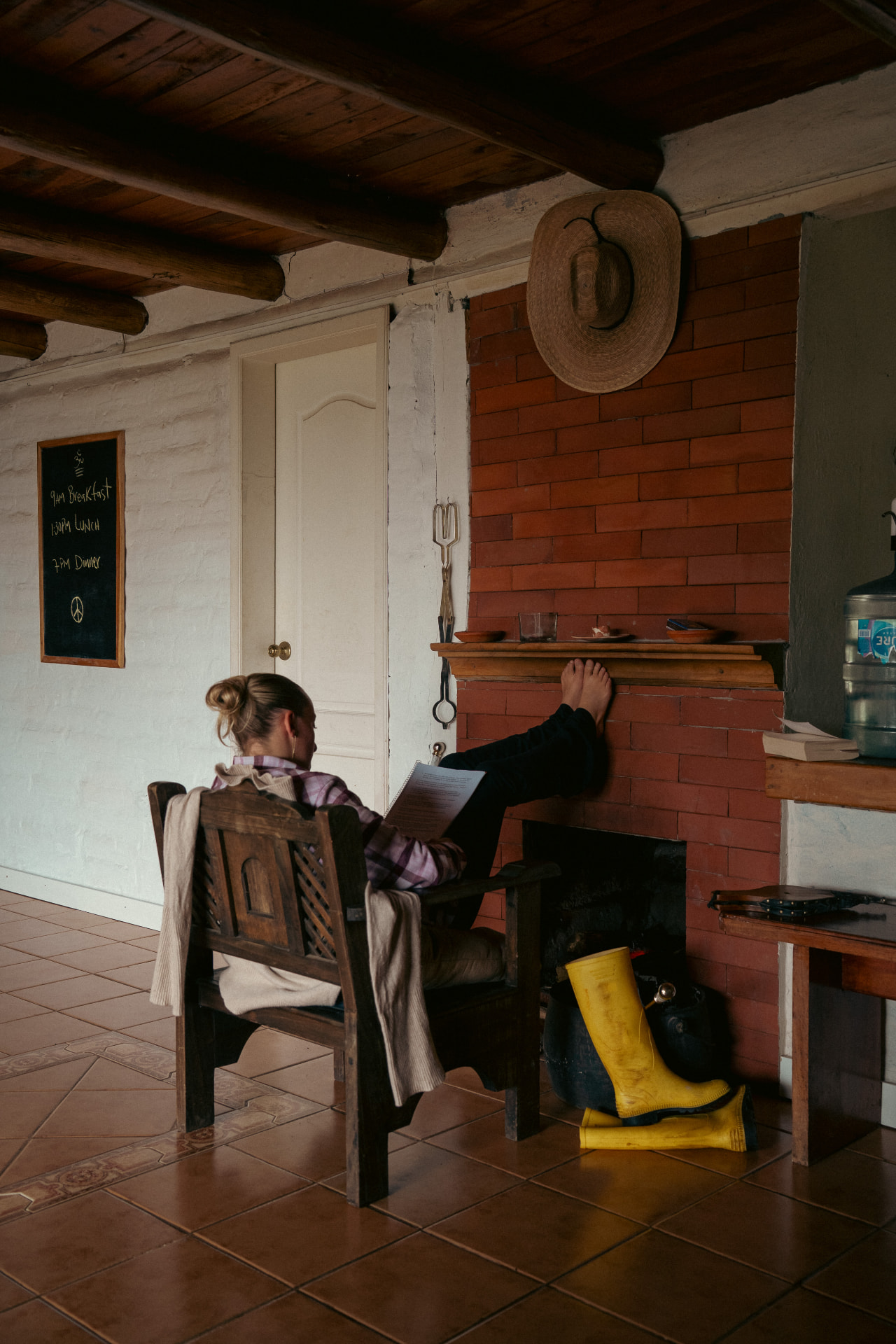 Nora reading her yoga teacher training notes in a warm, wood-beamed room