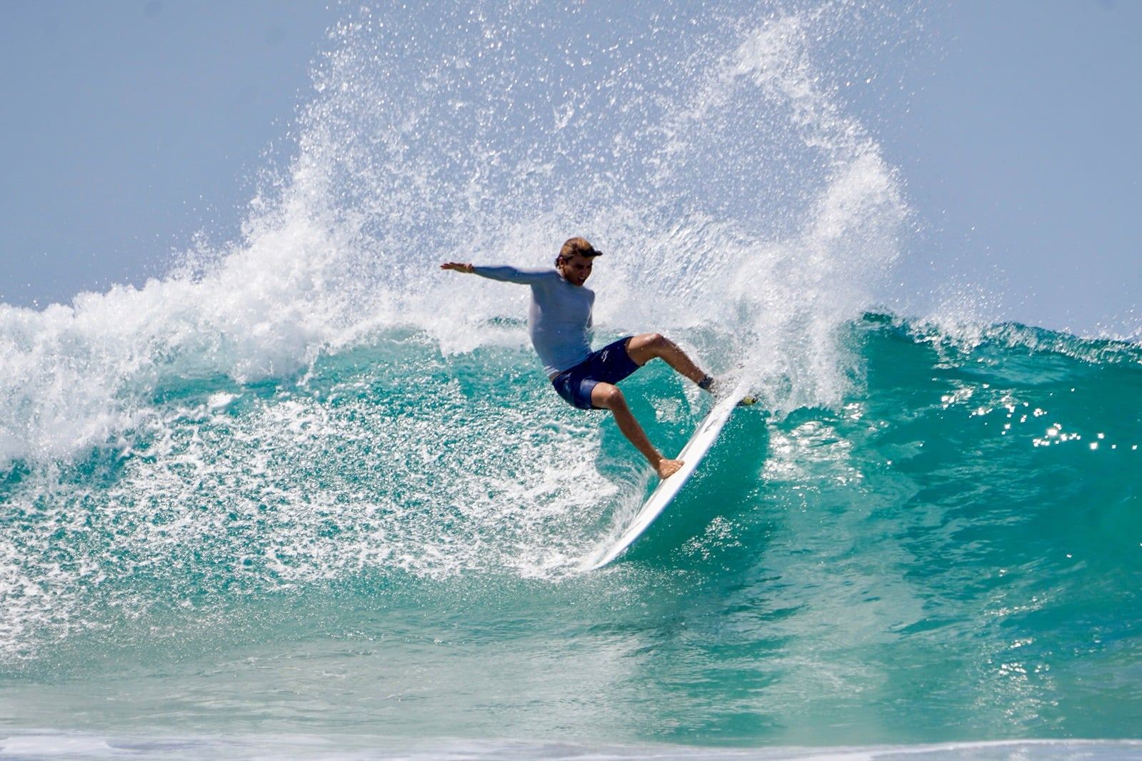 Surfer carving a big turn with spray flying